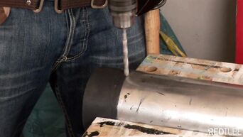 The locksmith is engaged in anal sex with a busty brunette in the workshop