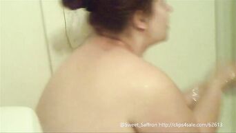 A fat woman with big tits is washing in the shower
